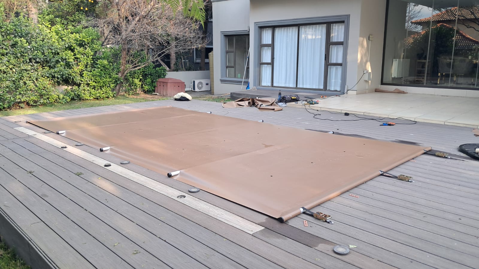Installation of a pool cover system on a timber deck around a swimming pool